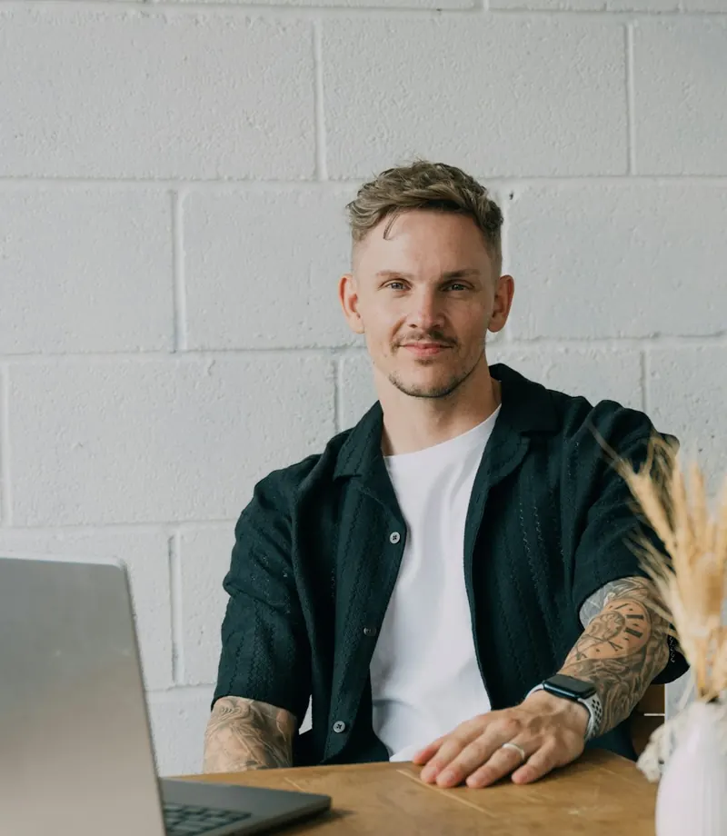 A business owner at his laptop at a wooden table